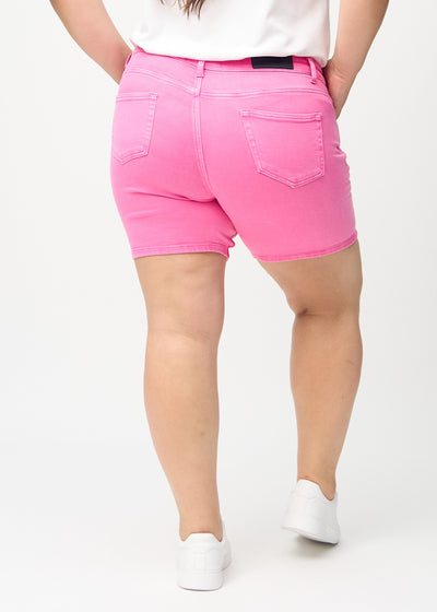 Lyserøde skinny short shorts set bagfra på en plus-size model, så man kan se hele produktet.