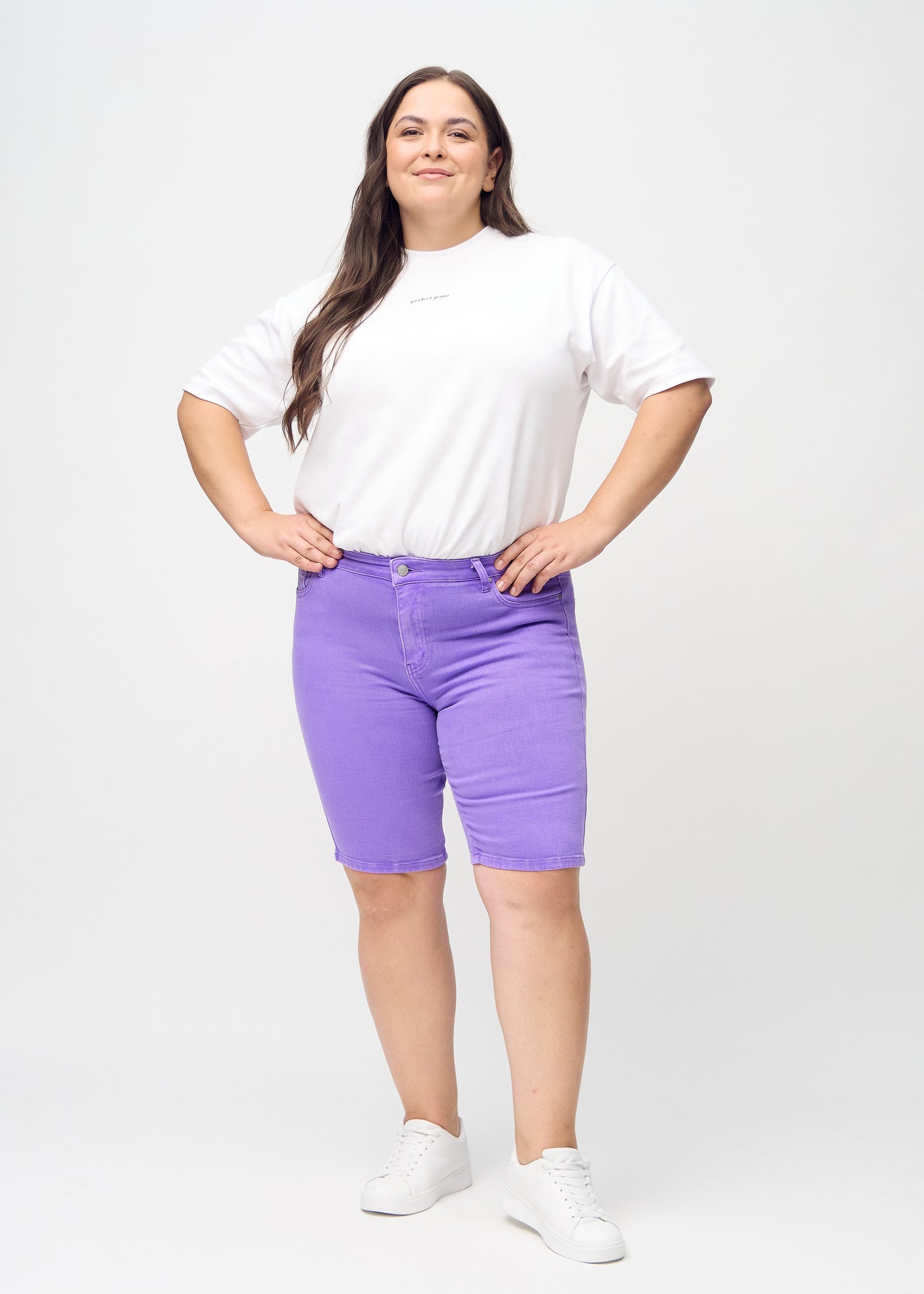 Fuldt billede af en plus-size model i lilla skinny middle shorts.