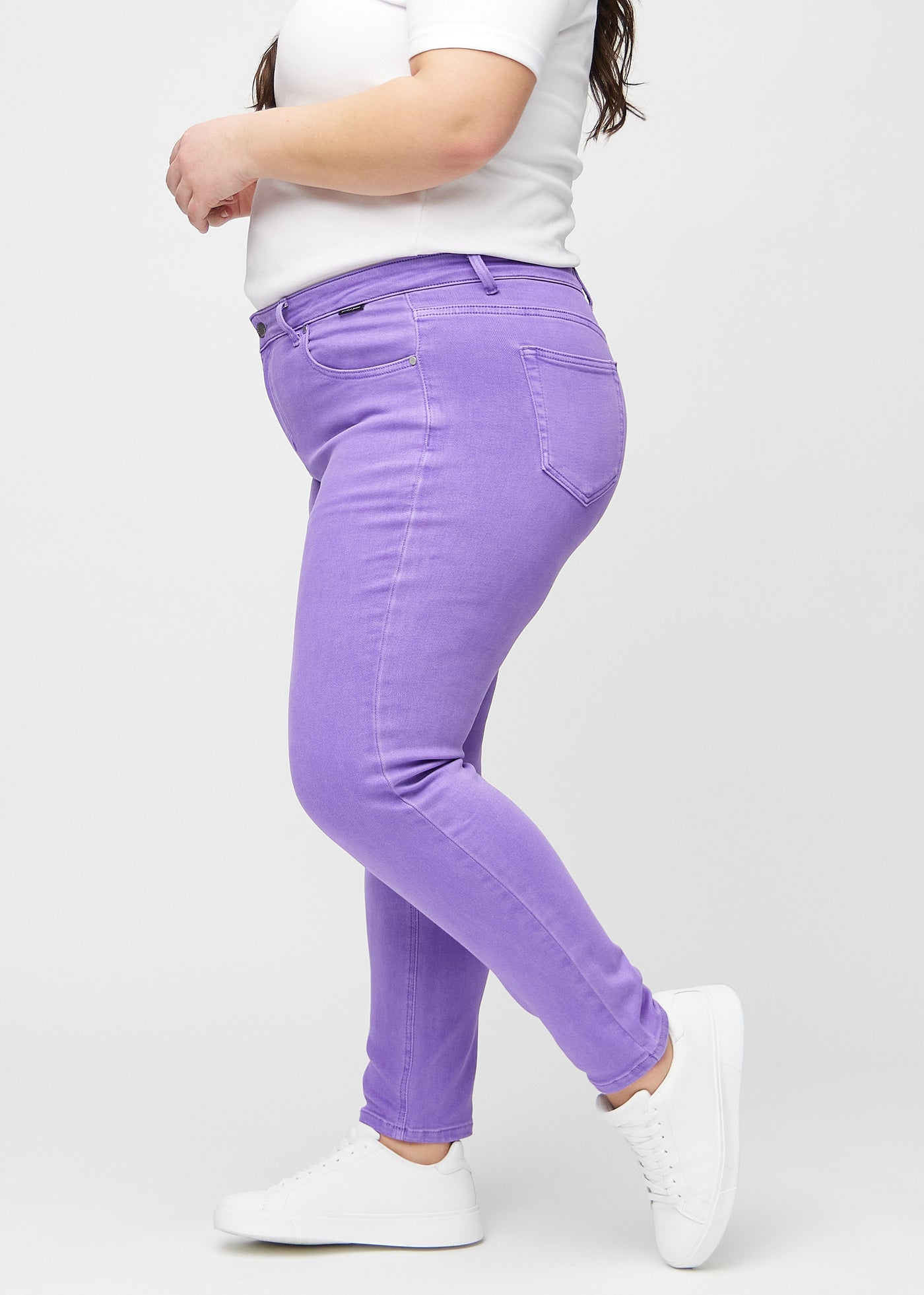 Lilla slim jeans set fra siden på en plus-size model.