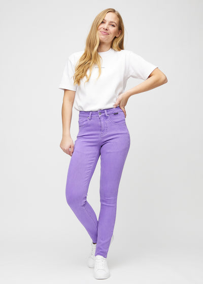 Fuldt billede af model i lilla slim jeans.