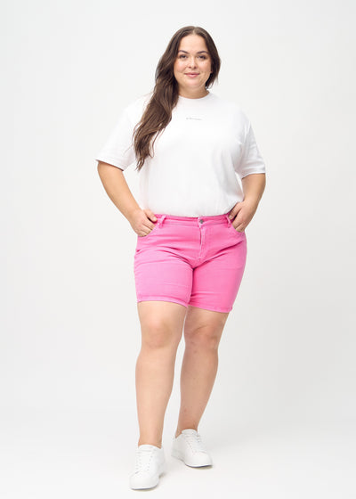 Plus-size model går ind i billedet, strækker i sine shorts, viser dem frem ved at dreje rundt, og forlader derefter billedet.